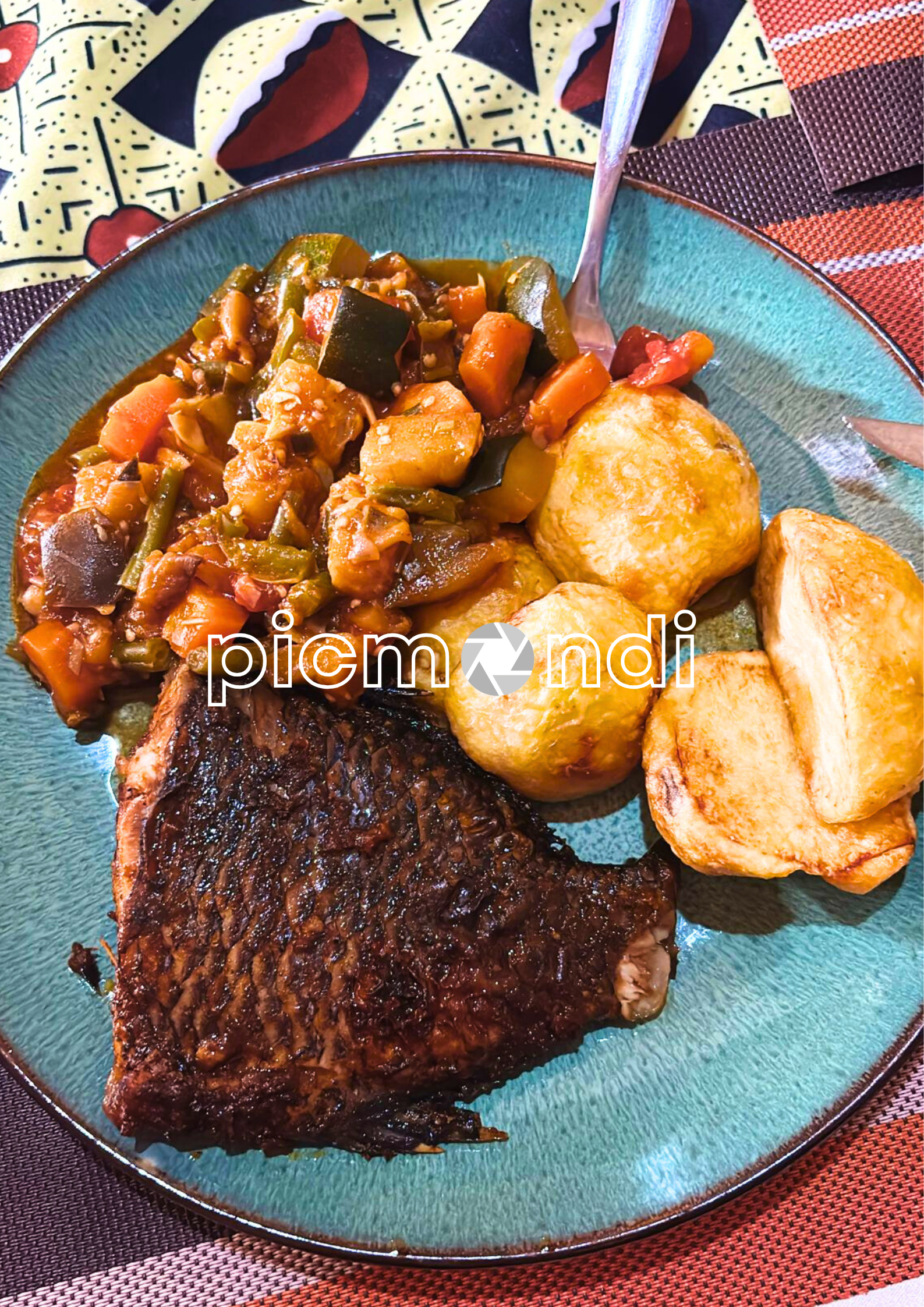 A dish of food, made with potatoes, vegetables and fried fish